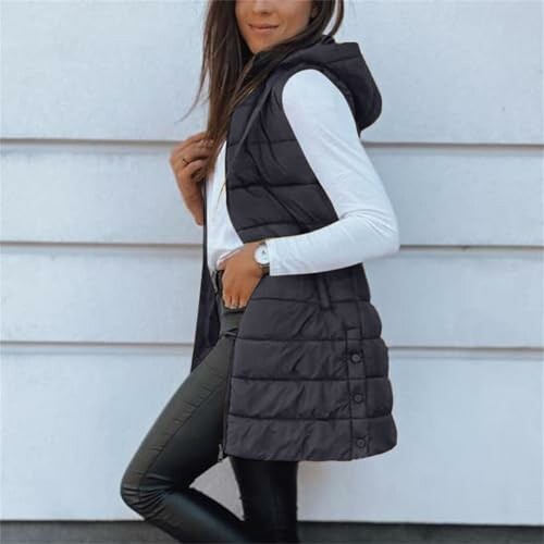 Mujer con chaleco acolchado negro y camiseta blanca.